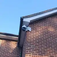 a security camera attached to the side of a brick building