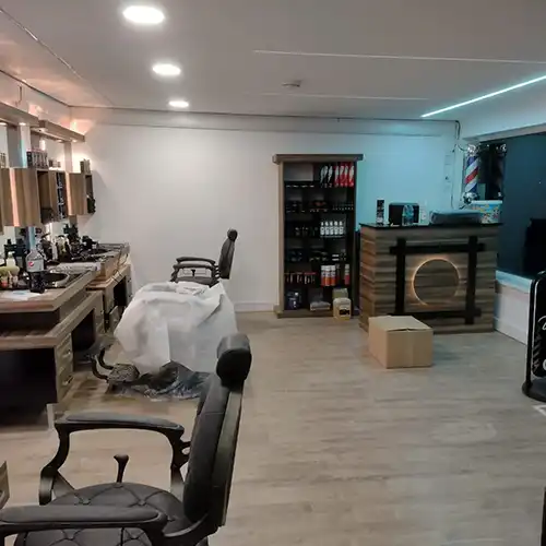 a barber shop with chairs and a mirror
